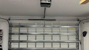 View from inside the garage of a closed steel garage door with a ceiling-mounted opener