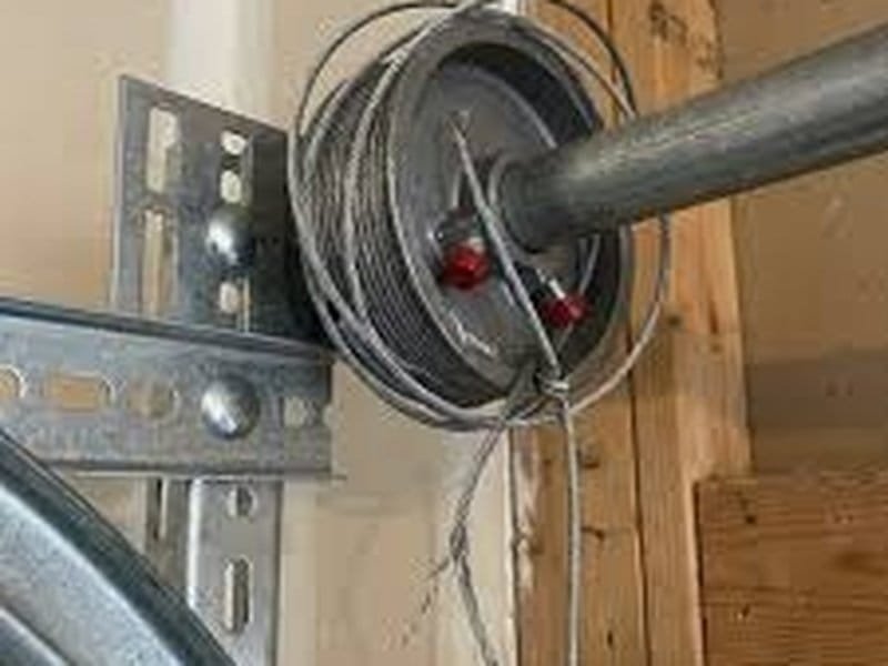 Close-up of a lift cable wound on a cable drum beside a spring bracket