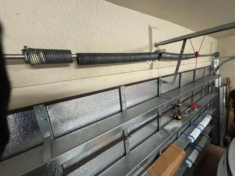 Spring and pulley hardware running along the overhead track of an insulated garage door